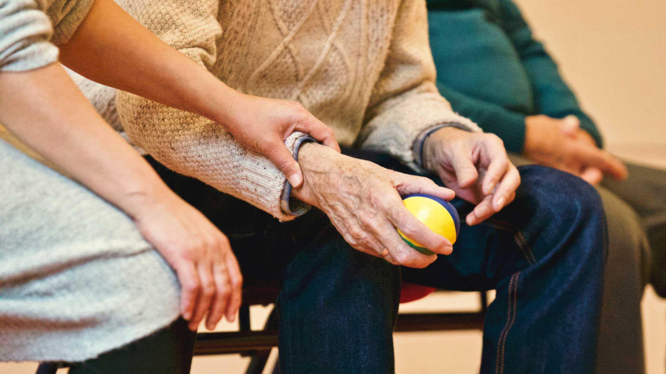 an elderly man holding a small ball